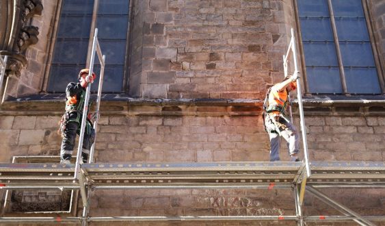 Dos operarios levantando el andamio en Santa Maria del Mar