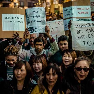 Barcelona, Spain. February 23rd, 2014: Immigrants holding placards march for immigration rights and papers through the city of Barcelona Credit:  matthi/Alamy Live News