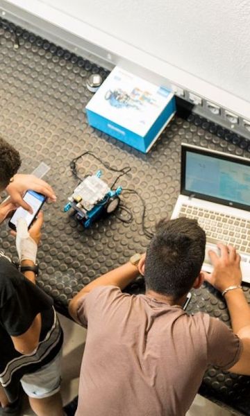 Jóvenes trabajando en un robot por Carlota Serarols