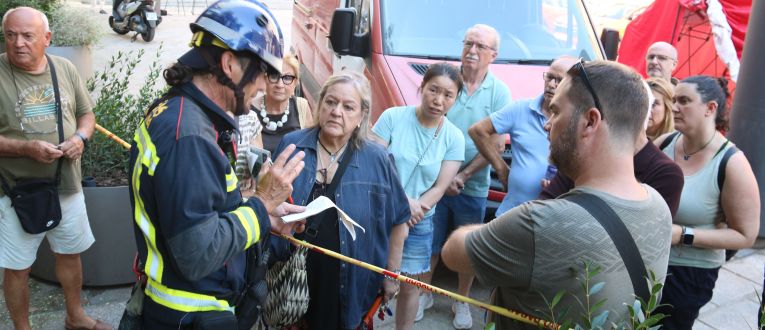 Un bomber amb veïns afectats per l'esvoranc del Putxet. © Miquel Codolar / ACN Un bomber amb veïns afectats per l'esvoranc del Putxet. © Miquel Codolar / ACN