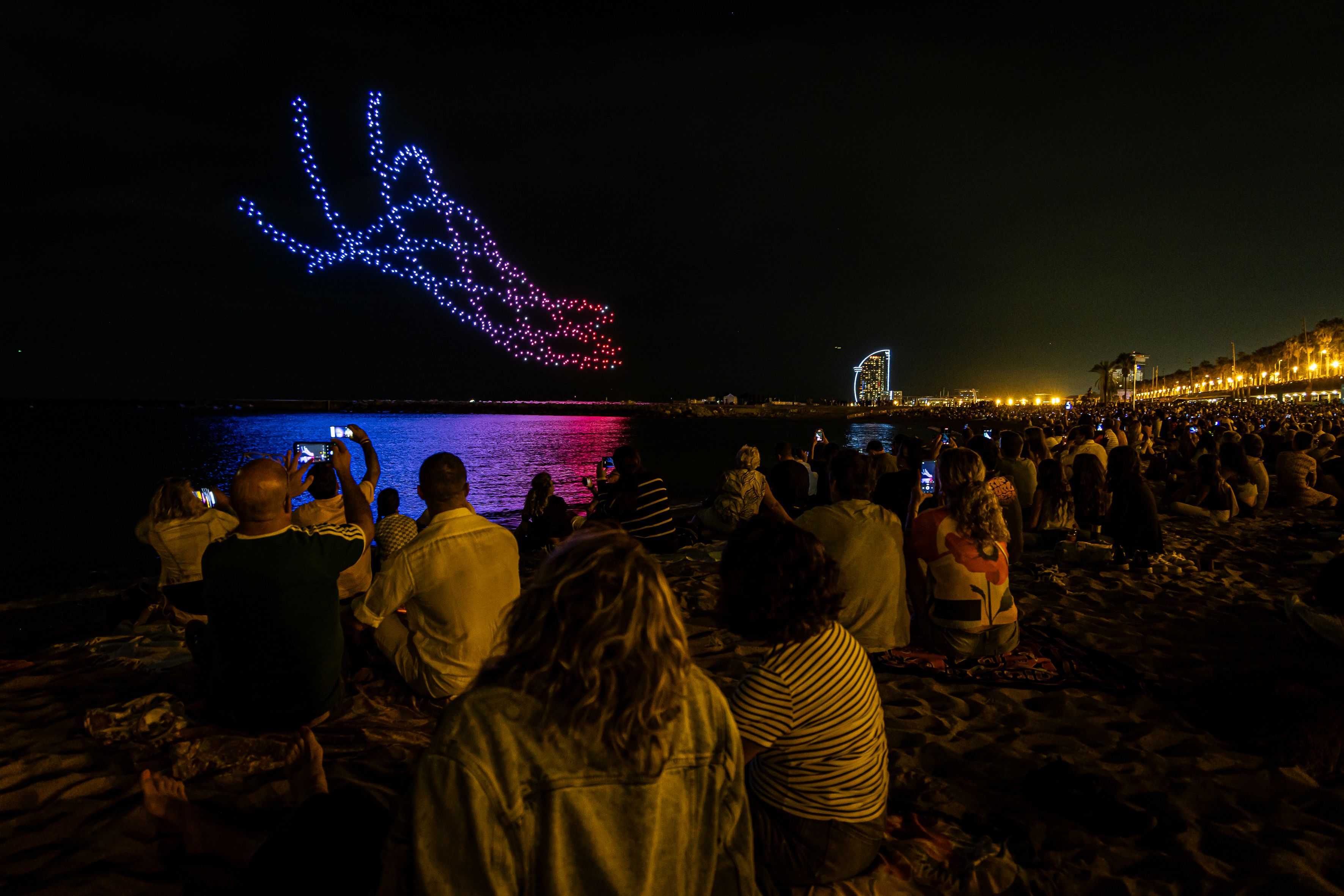 Una coreografia de 750 drons il·lumina el cel sobre la platja durant les festes de la Mercè. © Àngel Bravo
