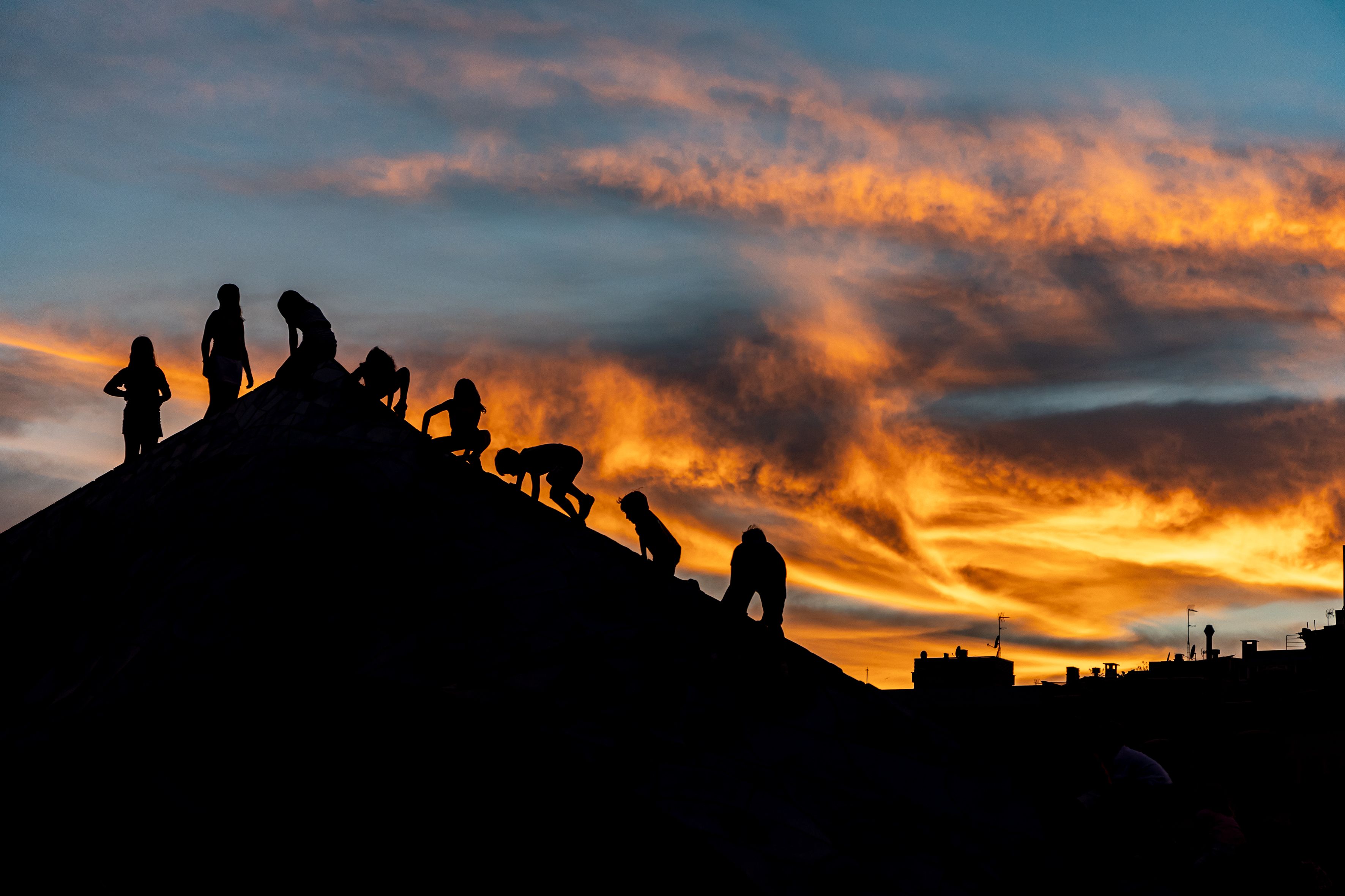 Infants juguen a la posta de sol, mentre el cel s’omple de tons càlids. © Àngel Bravo