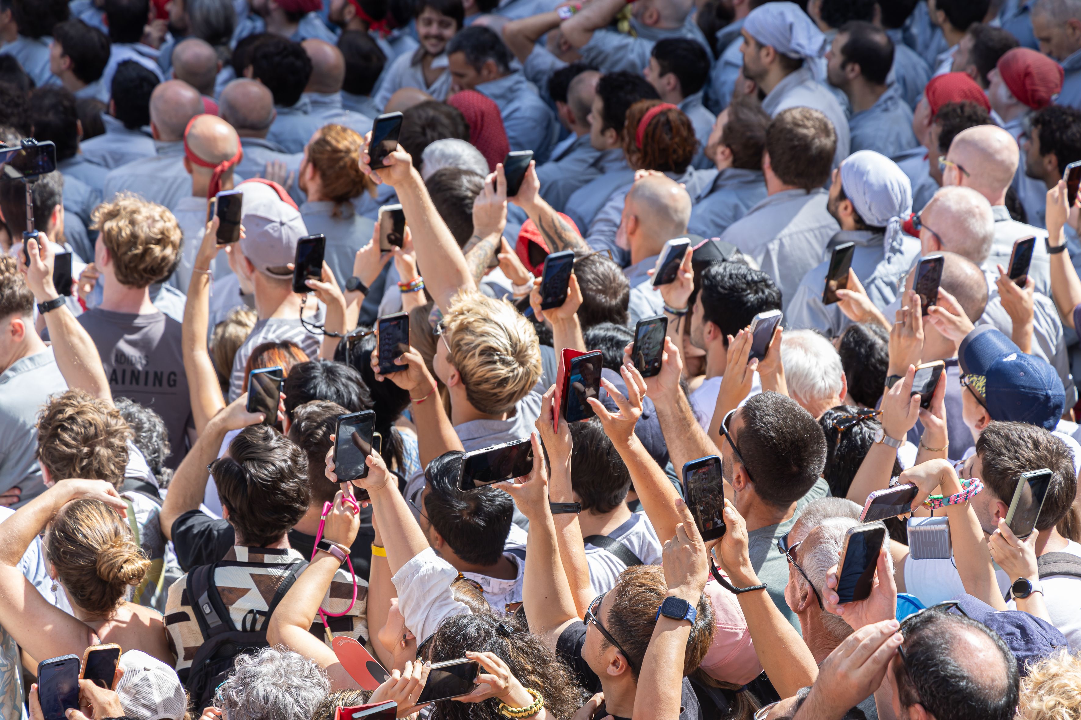 L’altra cara de la Diada Castellera: milers de persones immortalitzen amb els seus mòbils els castells a la plaça de Sant Jaume. © Àngel Bravo