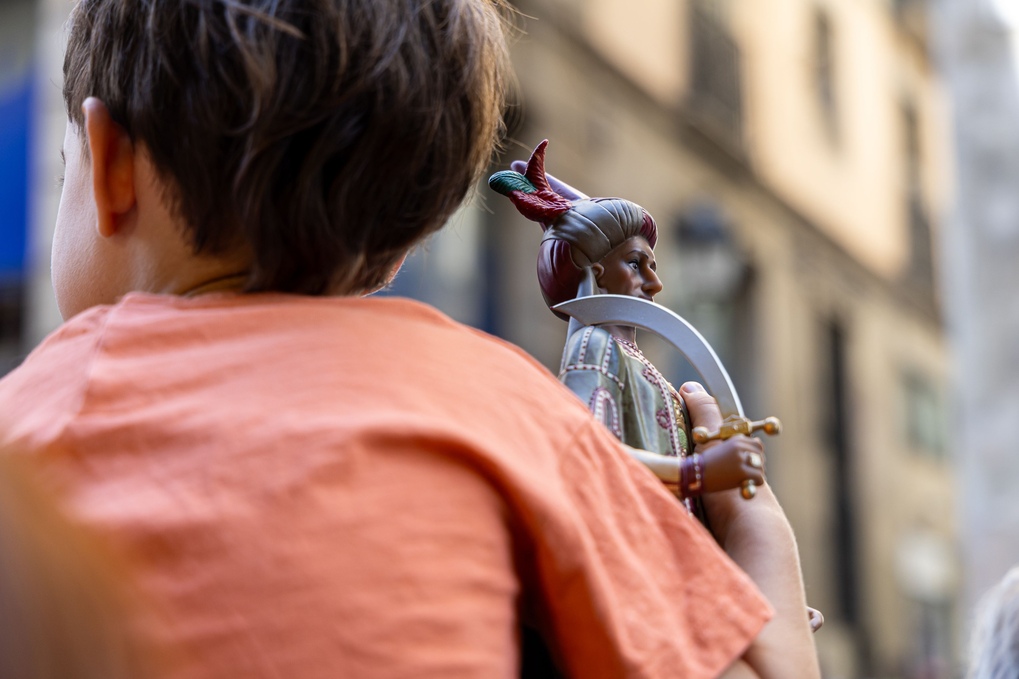 Un infant observa els gegants amb una joguina d’un gegant a la mà. © Àngel Bravo