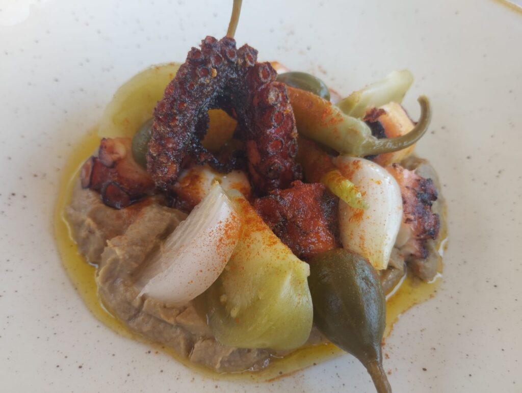Pulpo frito con hummus de lentejas y encurtidos.