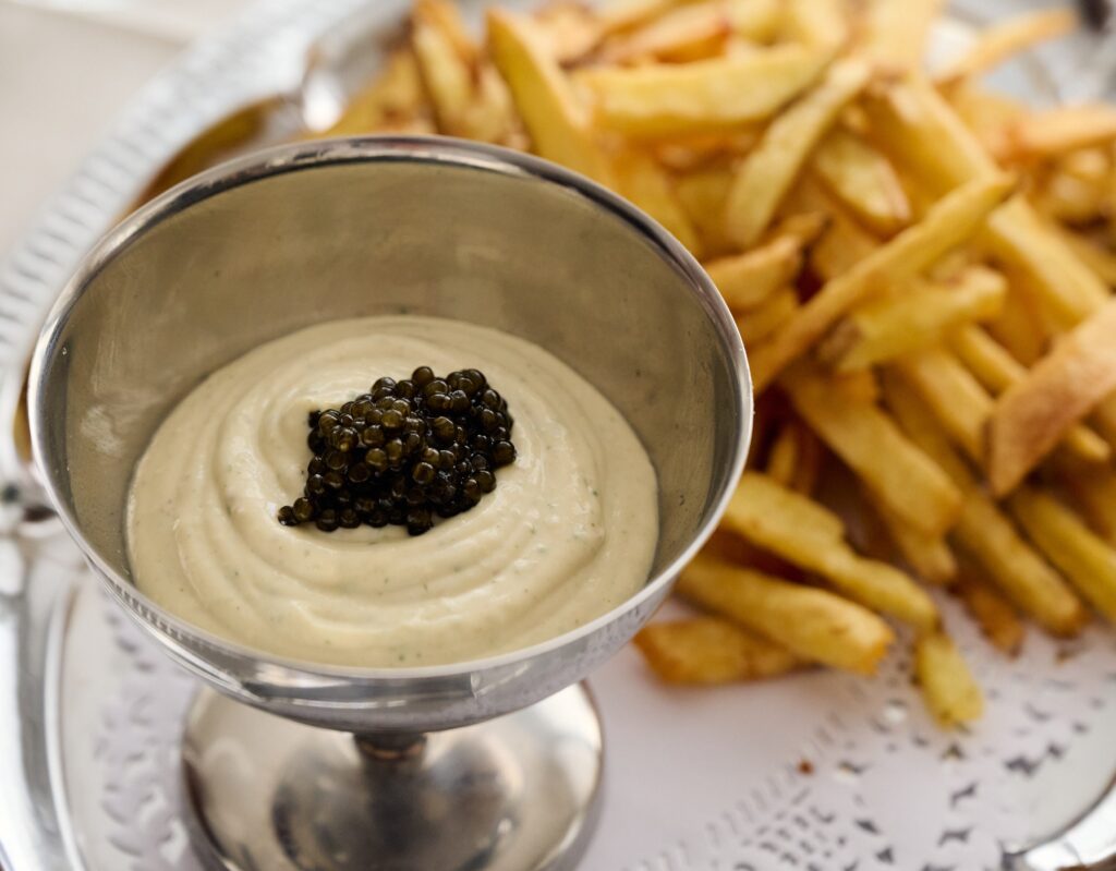 Patatas fritas con crema de anchoas y caviar.
