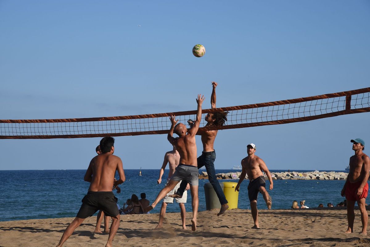 Jóvenes jugando a vóleibol en la playa de Sant Sebastià